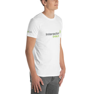 Man in white T-shirt with grey and  green Interaction 12 logo on front and IxDA logo on the right sleeve