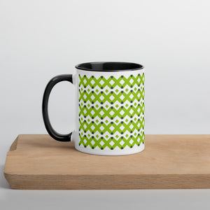 White ceramic mug with black handle and interior. Green X pattern imprint.